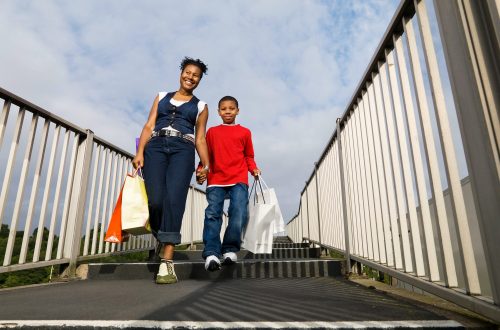 child carrying shopping with mother