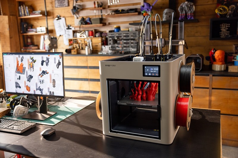 A desktop 3D printer and an industrial 3D printer placed side by side
