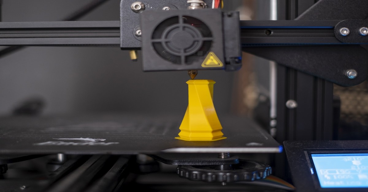 3D printer nozzle close to print bed showing bed leveling process