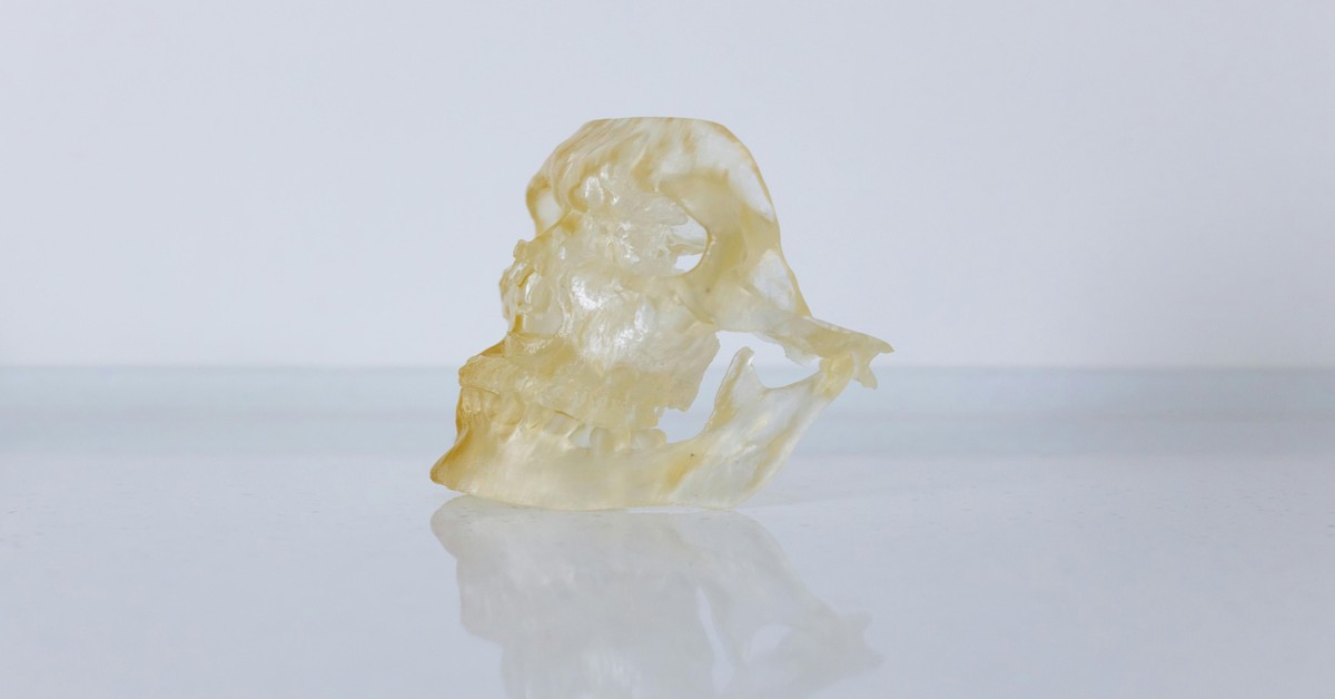Several amber bottles of 3D printer resin sitting on a desk with natural light.