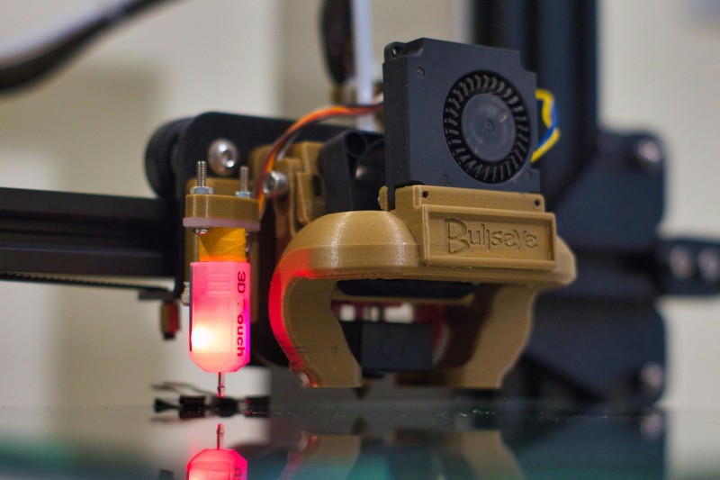 Hand holding a digital caliper measuring the wall thickness of a 3D printed part
