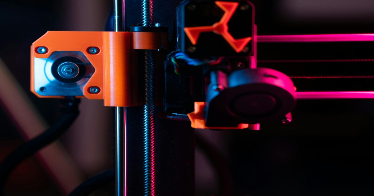 Active dual extruder 3D printer printing a two-color model with two filament spools visible