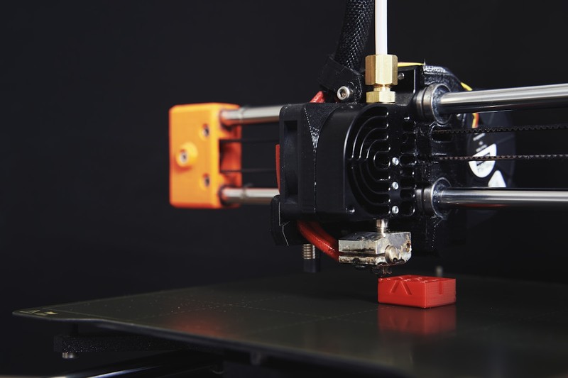 A 3D printer hotend and linear rail upgrade kit laid out on a workbench